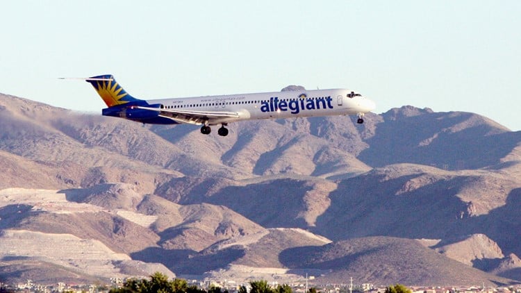Allegiant Airlines plane landing with dessert rock in background