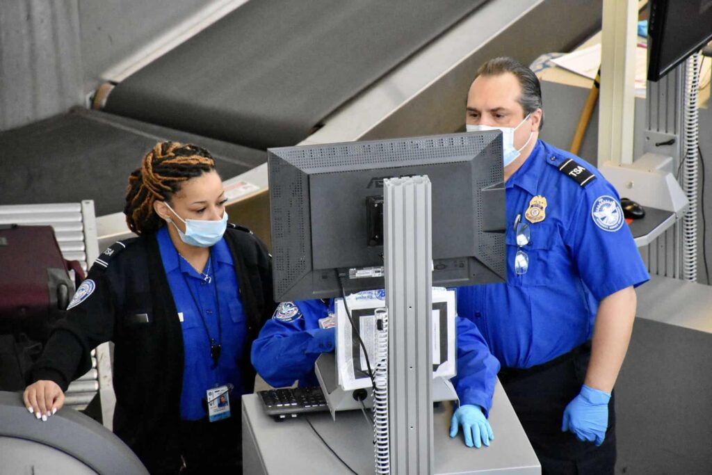 Three TSA officers looking at a computer screen