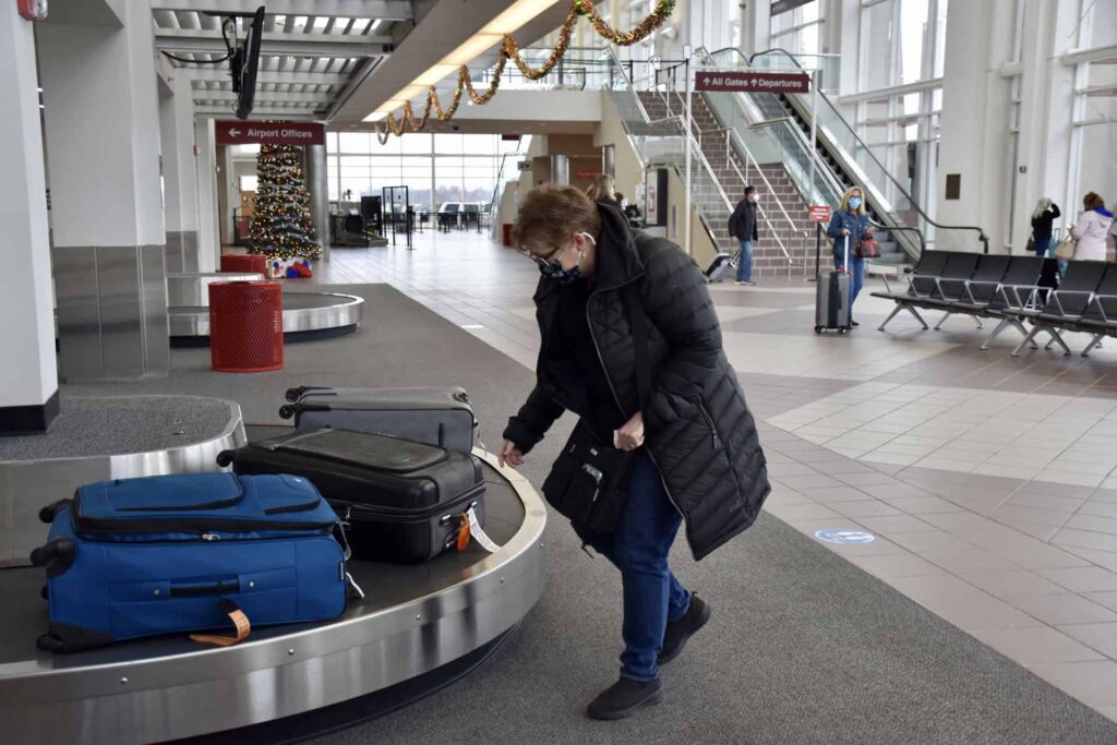 Woman picking up suitcase from baggage claim at MidAmerica Airport